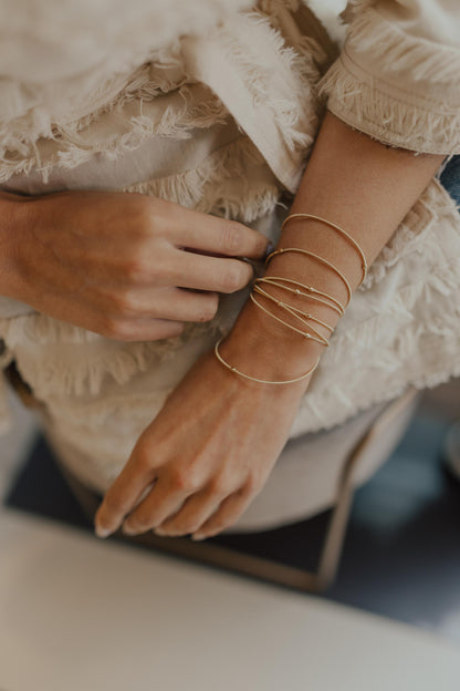 Pulseira Corda de Violão Bolinhas Dourado